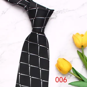 Detail shot of a stylish black men's tie with silver geometric pattern on marble.