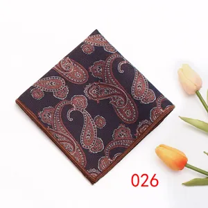 Dettaglio di una pochette da uomo con stampa cachemire, elegante accessorio marrone.