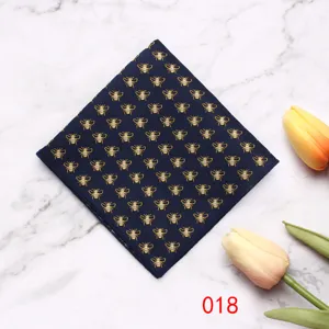 Heren pochet met elegant gouden geborduurd bijenmotief op donkerblauwe stof detail.