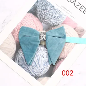 Detailed view of the blue velvet bow tie with rhinestone center knot, elegant accessory.
