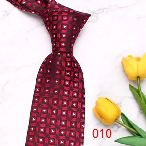Close-up detail view of retro geometric red men tie featuring elegant patterns displayed on marble.