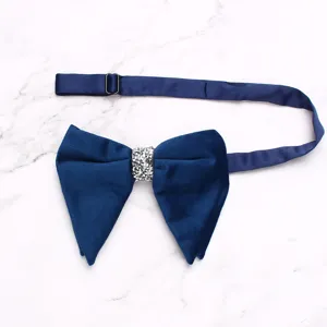 Detailed view of navy blue velvet bow tie with sparkly rhinestone center and adjustable strap.