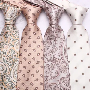 Close-up detail shot of elegant light paisley and geometric pattern neckties for men.