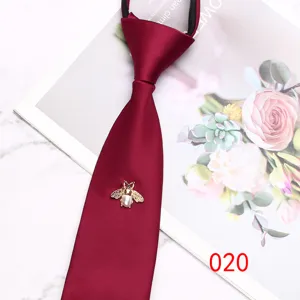 Burgundy zipper tie close-up featuring an elegant gold bee brooch with a pearl body.