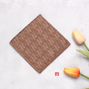 Pocket square detail close-up showing intricate brown leaf pattern design, elegant suit accessory.