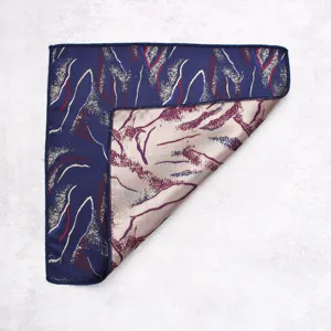 Detailed view of folded silk pocket square showing abstract pattern and neat edge stitching.