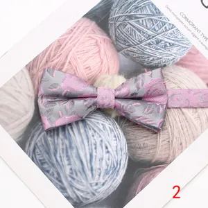 Elegante pajarita de seda para hombre con motivo floral gris y rosa, toma detallada.