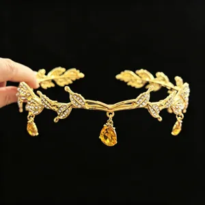 Primer plano de una tiara de novia de hojas doradas con diamantes de imitación.