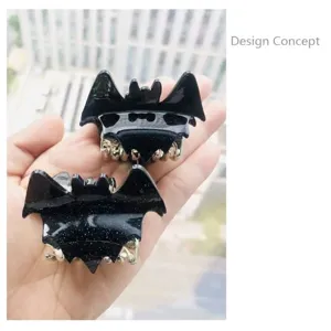 Close-up of black glittery bat-shaped hair claw clips for Halloween festival hair styling