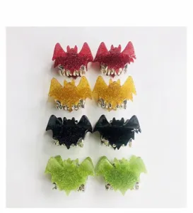 Detailed view of colorful glittery bat-shaped hair claw clips for festive Halloween hair styling