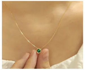 Close-up detail of 14K gold plated sterling silver necklace with round green emerald pendant