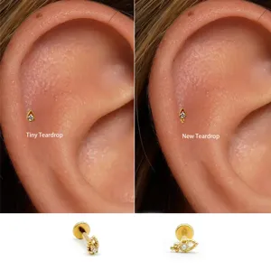 Nahaufnahme von winzigen goldenen Teardrop-Labret-Ohrsteckern für Knorpel- und Tragus-Piercing