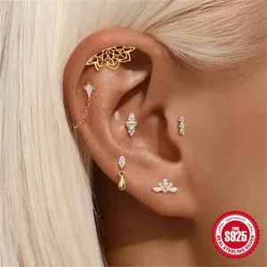 Nahaufnahme von S925 Sterling Silber Ohrpiercings mit Lotus- und Sterndesign in Goldoptik