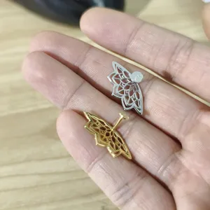 Nahaufnahme von S925 Sterlingsilber und Gold Lotus Knorpel Ohrsteckern auf Fingern