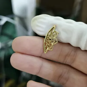 Detailansicht eines goldenen, hohlen Lotusblumen-Piercing-Ohrrings für den Knorpel.