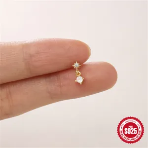 Nahaufnahme eines winzigen S925 Gold-Ohrsteckers mit achtzackigem Stern auf den Fingern