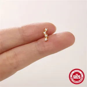 Nahaufnahme eines zarten S925 Sterling Silber Gold Ohrsteckers mit vier Kristallen.