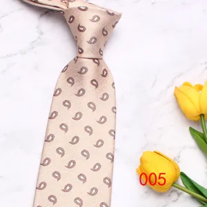 Detail view of light-colored paisley necktie, classic 8cm business casual tie on marble.