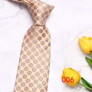 Detail view of a classic golden geometric pattern silk tie with elegant floral motifs for men.