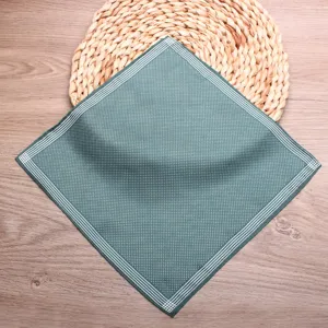 Detailed close-up of green polka dot pocket square, silk handkerchief suit accessory.