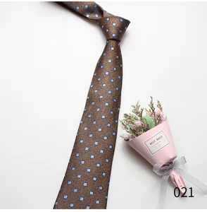 Detail view of brown mens necktie featuring elegant small blue floral geometric patterns.