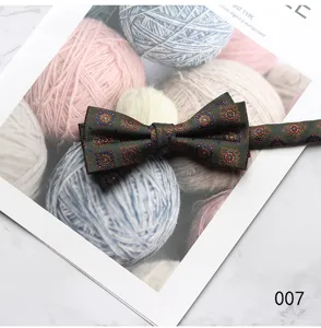 Detail shot of dark green mens bow tie with vintage geometric pattern for formal wear.