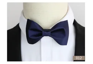 Detail van een elegante donkerblauwe satijnen vlinderdas gedragen op een wit overhemd.