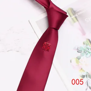 Burgundy wedding tie detail showing the classic Chinese double happiness emblem and silk fabric.