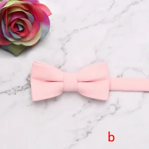 Pink children bow tie detail view, solid fabric texture with adjustable strap for kids.