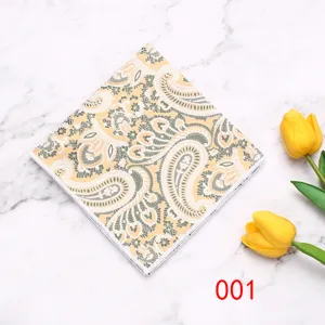 Vista dettagliata di una pochette gialla con motivo paisley su marmo con tulipani.