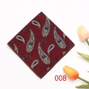 Gedetailleerde close-up van een bordeauxrode paisley pochet met bruine gerolde randen.