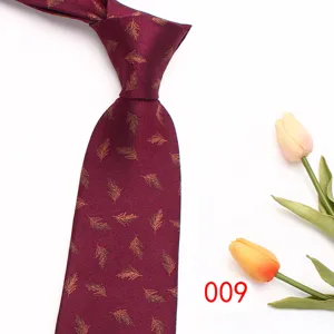 Close up detail of burgundy mens tie with gold feather pattern and fine chevron fabric weave.