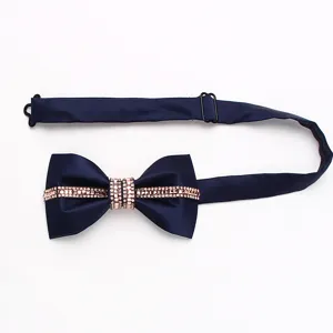 Primo piano dettagliato di un farfallino blu scuro con decorazioni di strass brillanti.