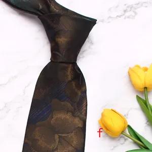 Close-up detail of a dark brown floral jacquard men necktie on white marble background.