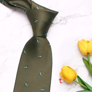 Close-up detail of dark green men's tie featuring cute white marine animal print pattern.