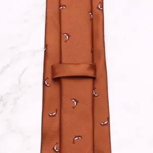 Detailed view of a brown men's necktie featuring a playful small whale pattern, fine texture.