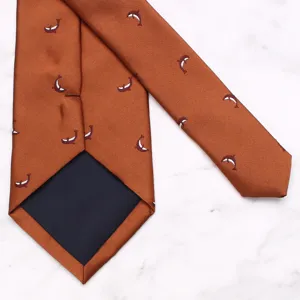 Detailed shot of orange silk necktie featuring cute small whale pattern, 8cm wide business wear.