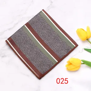 Gedetailleerd overzicht van een pochette met geometrische strepen op marmeren achtergrond.