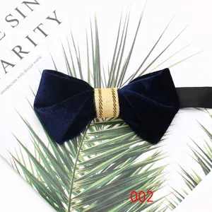 Close-up detail of dark blue velvet bow tie with gold center stripe for formal suit.