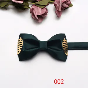 Detail shot of the dark green wedding bow tie featuring elegant gold double happiness metal accents.