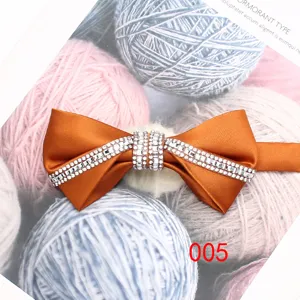 Dettaglio farfallino arancione con strass che mostra squisita decorazione in cristallo.