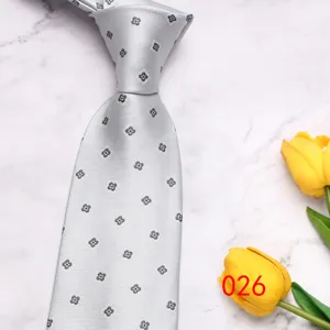 Detail view of light gray men's business tie featuring elegant floral pattern for wedding.