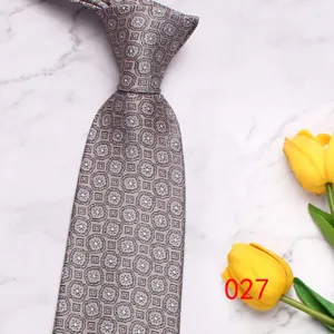 Close-up detail of the classic grey paisley men's tie, showing fine geometric woven texture.