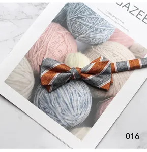 Detail shot of a stylish orange and grey striped bow tie on a magazine prop, elegant and neat.