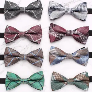 Detailed close-up of multiple plaid bow ties with classic British style patterns.