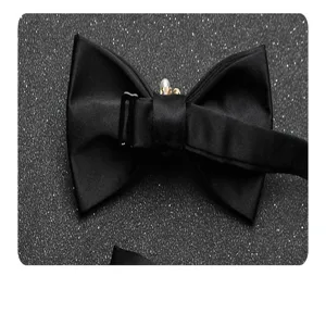 Dettaglio del farfallino nero in satin con centro in perla strass e cinturino regolabile.