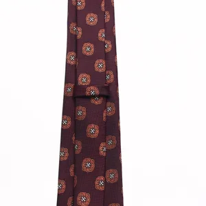 Detailed view of the burgundy men's formal necktie featuring elegant woven medallion floral patterns.