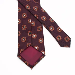 Detailed view of the back and medallion patterned fabric of the burgundy men's business necktie.