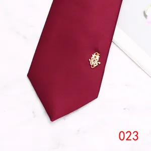 Close-up detail of burgundy men wedding necktie with gold double happiness decoration.