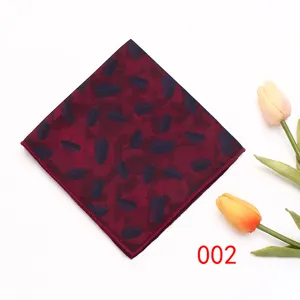 Gedetailleerd overzicht van bordeauxrode pochet met blauw bladpatroon, elegant herenpak accessoire.